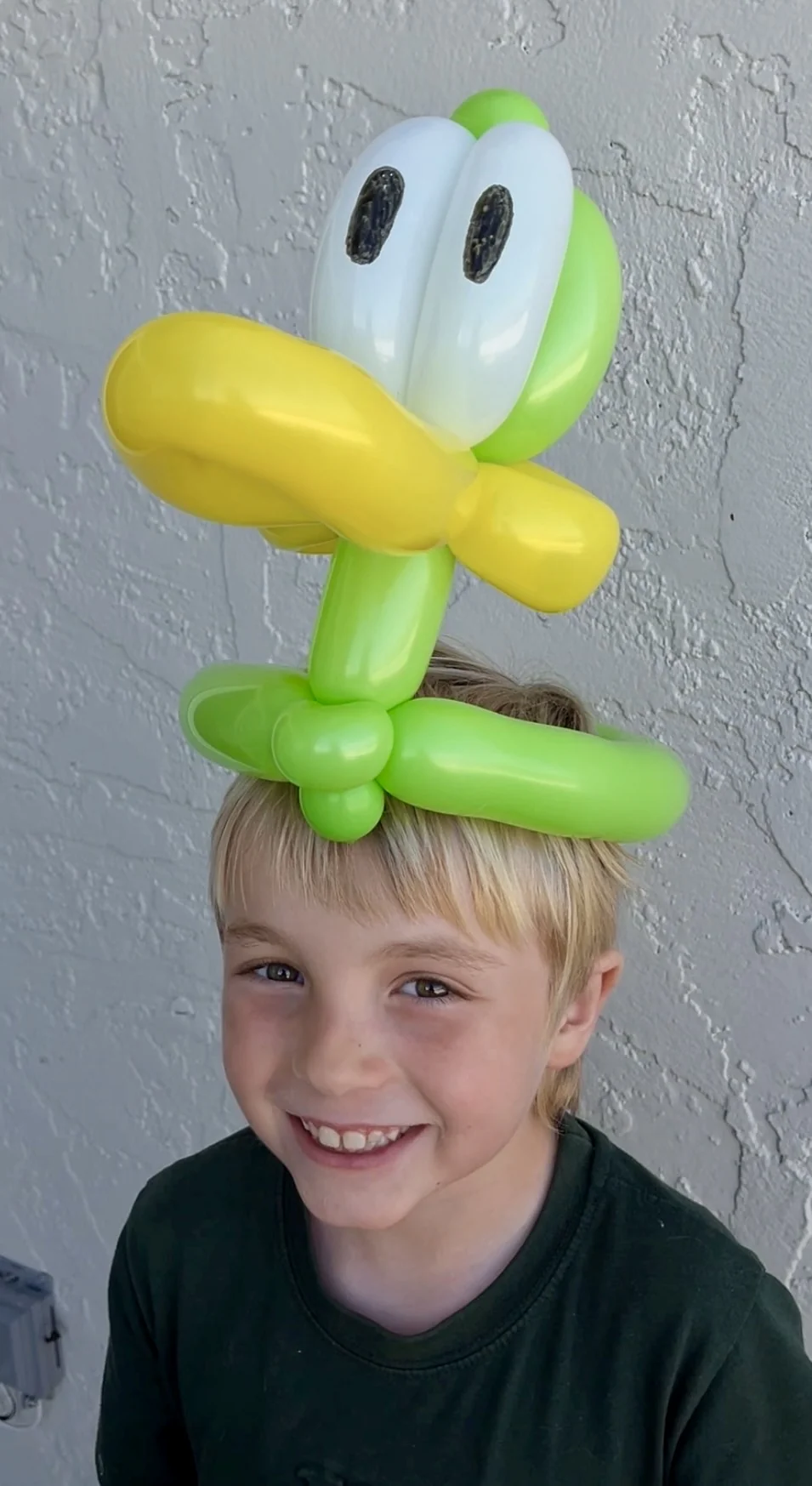 Happy child wearing a balloon hat by Happy Faces LA at a birthday party