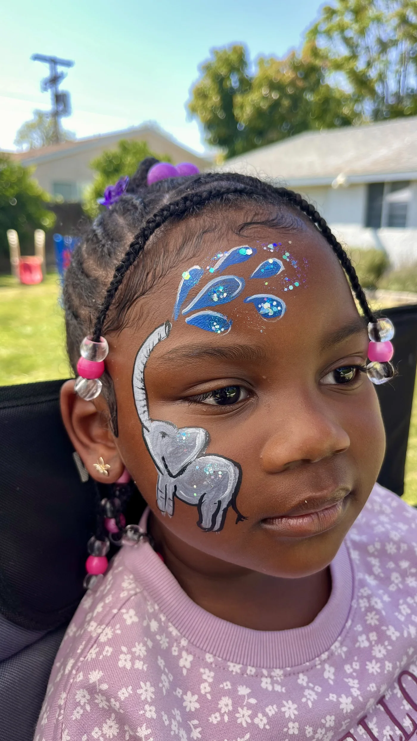 Elephant cheek painting with glitter and water drop details at a kids party in Los Angeles