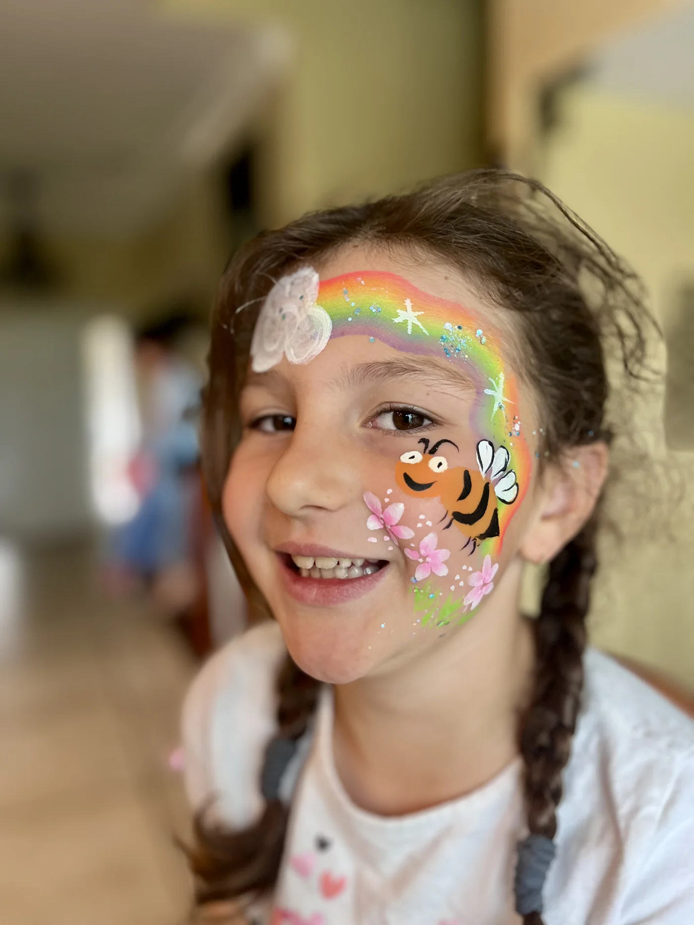Rainbow and flower cheek painting at a kids birthday party in Los Angeles by Happy Faces LA